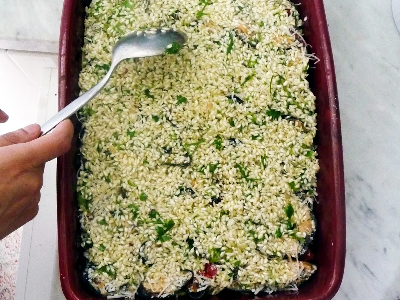 Montage du riso patate e cozze dans la tielle, troisième couche: moules, parmesan et riz